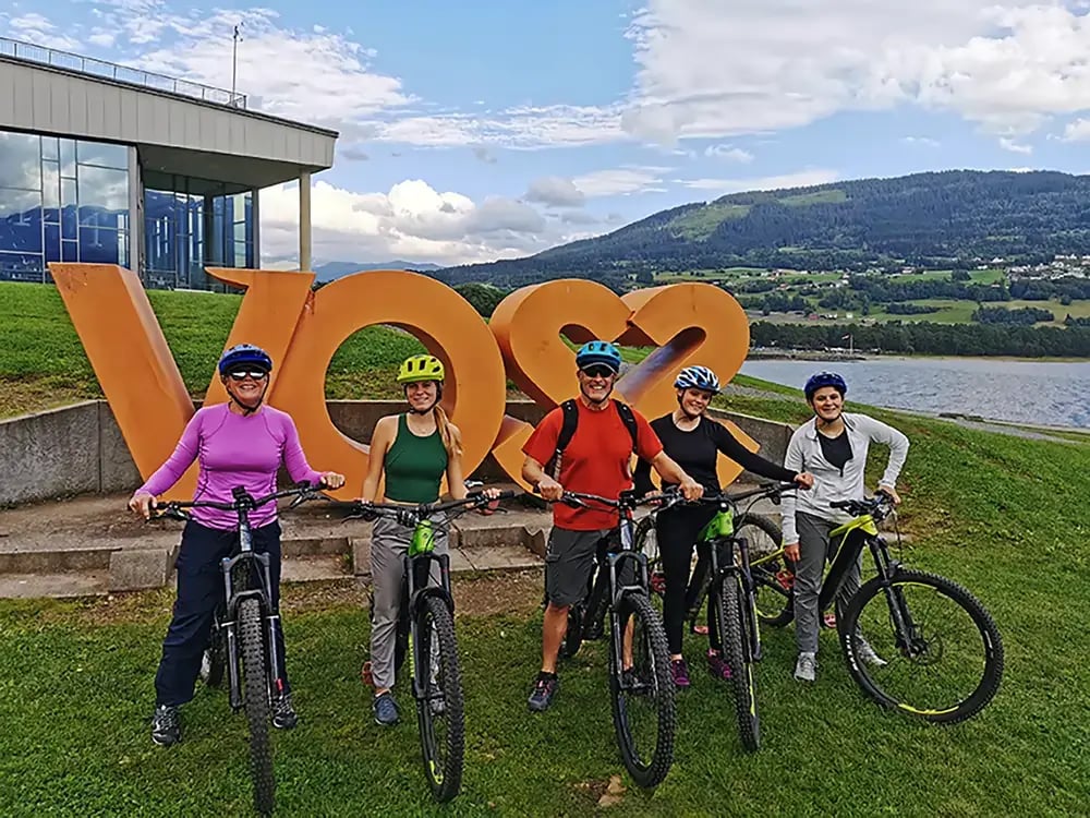 Cyclists posing at Voss sign